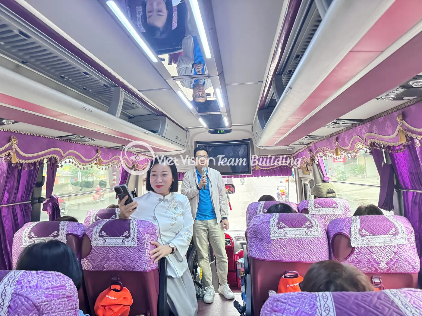MC điều phối đoàn trên xe trong chương trình team building Hạ Long cho doanh nghiệp
