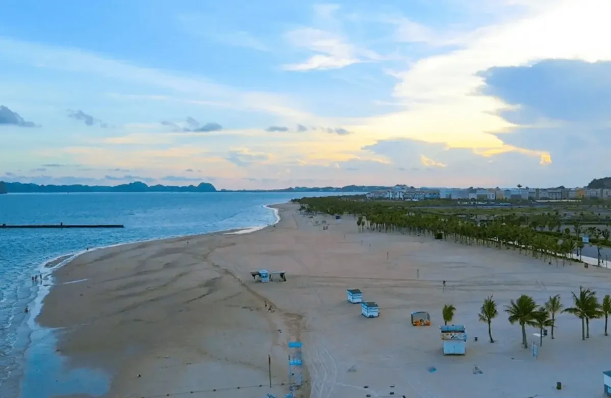 Toàn cảnh chương trình team building Amazing Race biển tại bãi biển Bãi Cháy Hạ Long — các đội đang thi đua giải mã mật thư trên cát trắng với phông nền vịnh Hạ Long