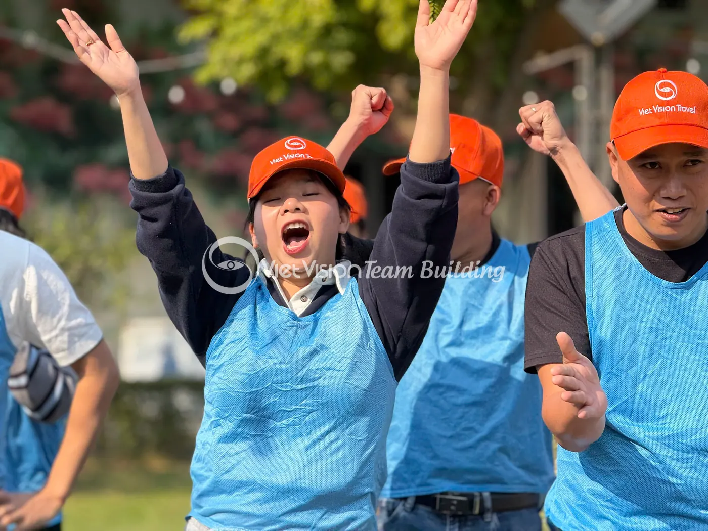Đội chơi áo xanh cổ vũ trong chương trình team building ngoài trời