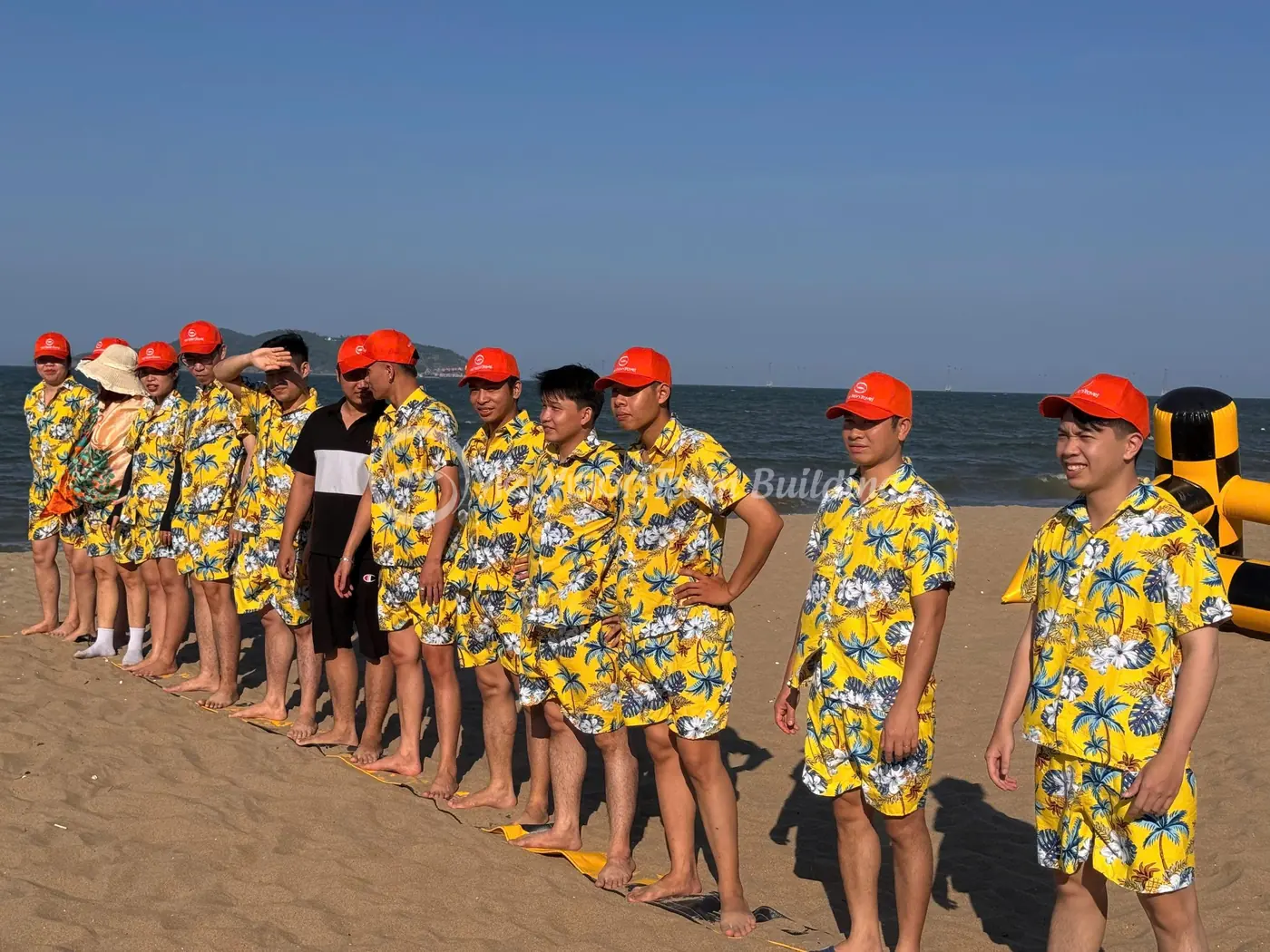 Đội chơi mặc đồng phục đứng theo hàng trước khu vực team building