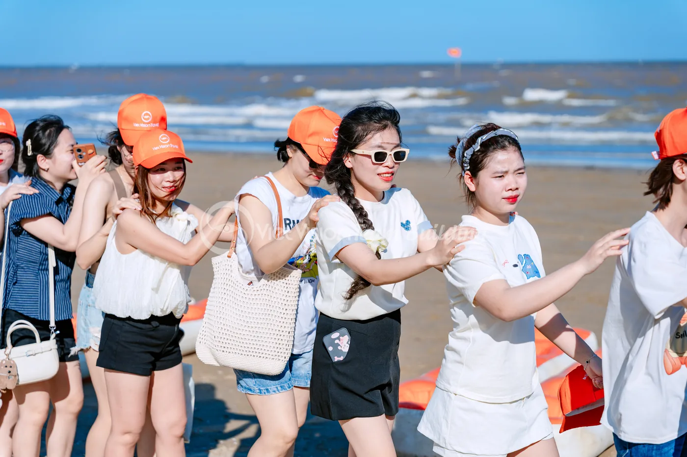 Đội chơi xếp hàng trên bãi biển trong chương trình team building theo chủ đề