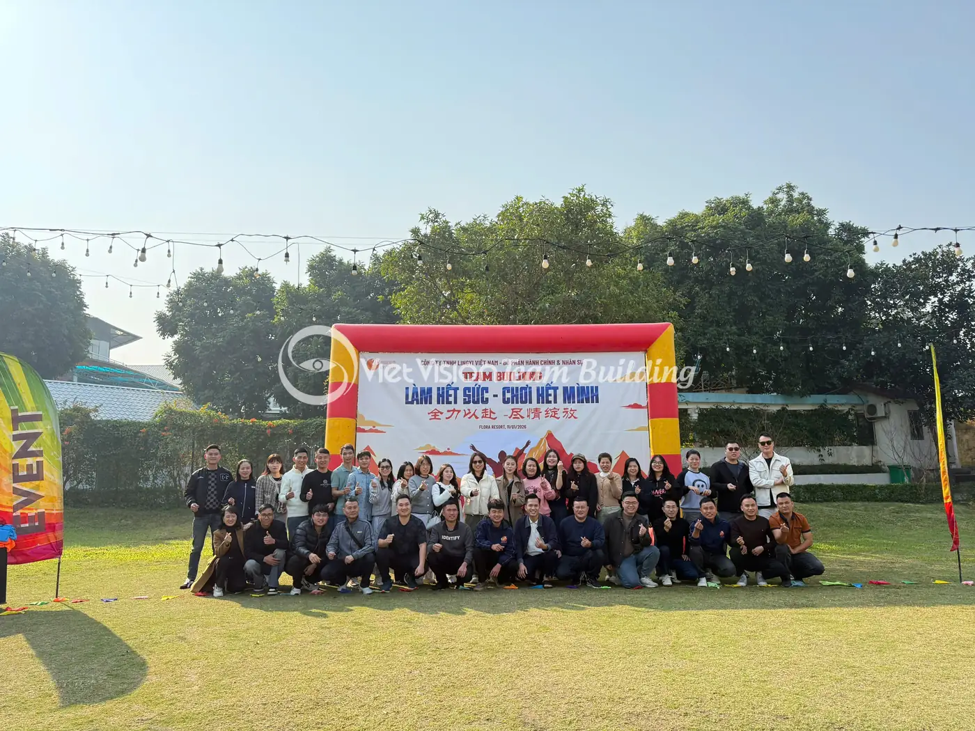 Đoàn công ty chụp ảnh trước backdrop trong chương trình team building ngoài trời