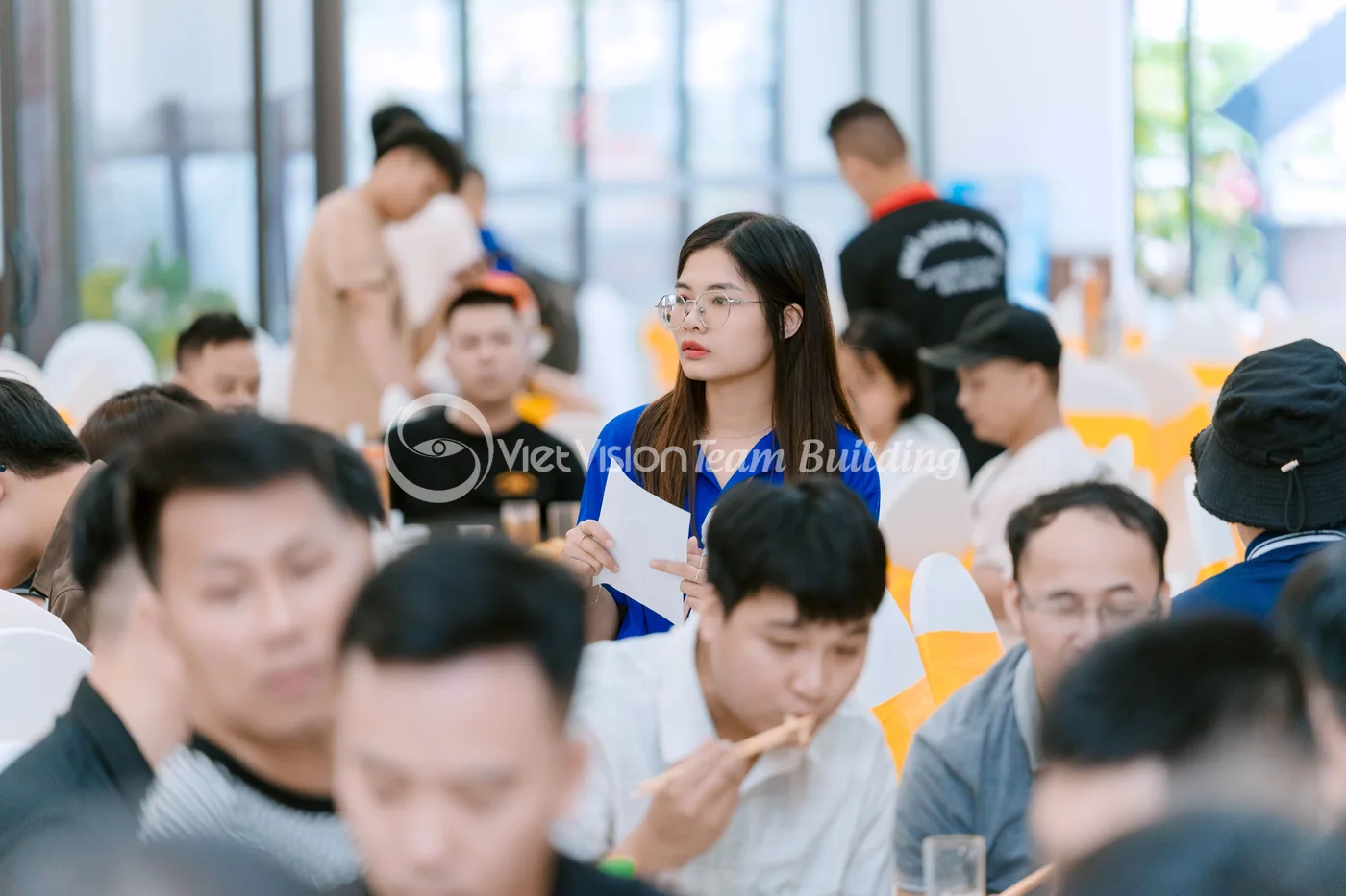 Điều phối viên hướng dẫn nhóm đọc manh mối trong phần giải mật thư team building
