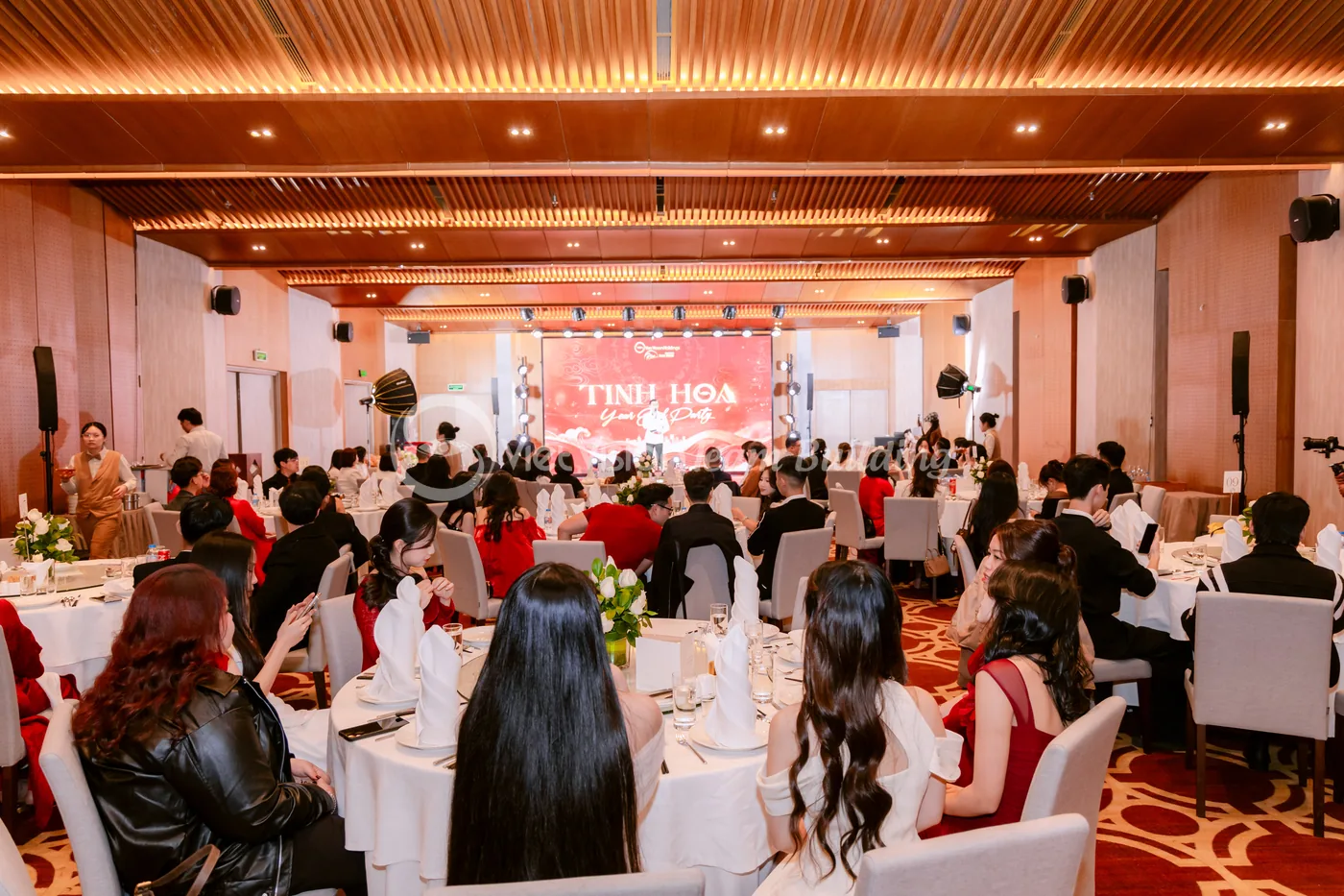 Không gian gala công ty với sân khấu và backdrop nhận diện chương trình