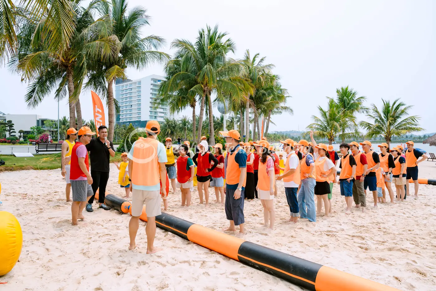 Đội chơi team building Amazing Race trên bãi biển đang tập trung nghe hướng dẫn trước khi vào trạm