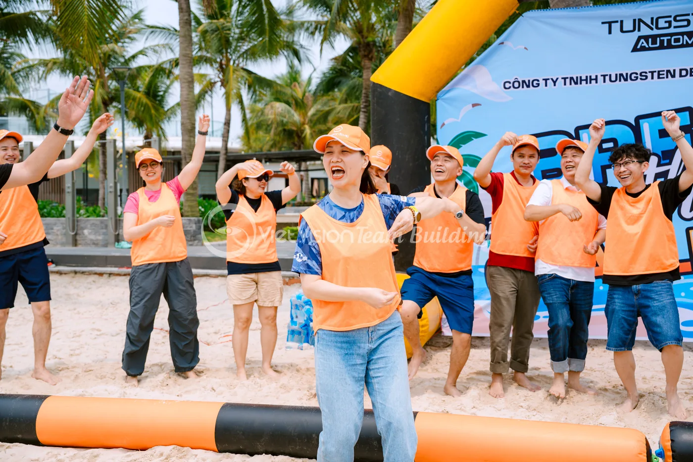Nhân viên cười và cổ vũ nhau trong chương trình team building