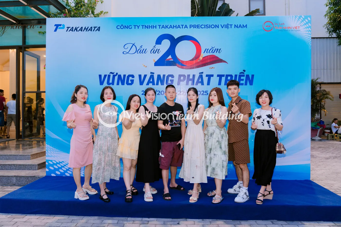 Nhân sự chụp ảnh lưu niệm trước backdrop kỷ niệm công ty tại Hạ Long