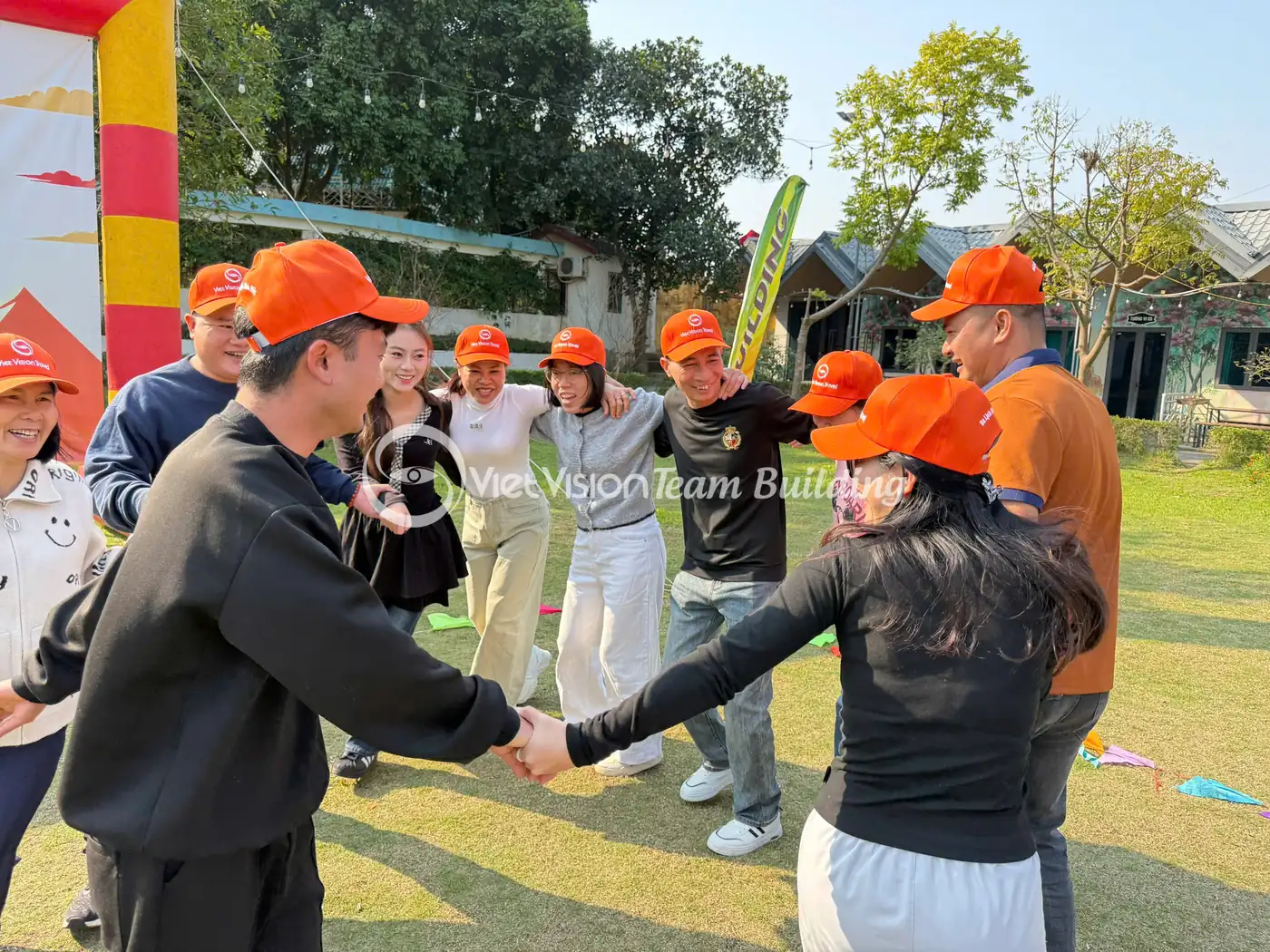 Nhóm nhân sự nắm tay thành vòng tròn trong hoạt động team building
