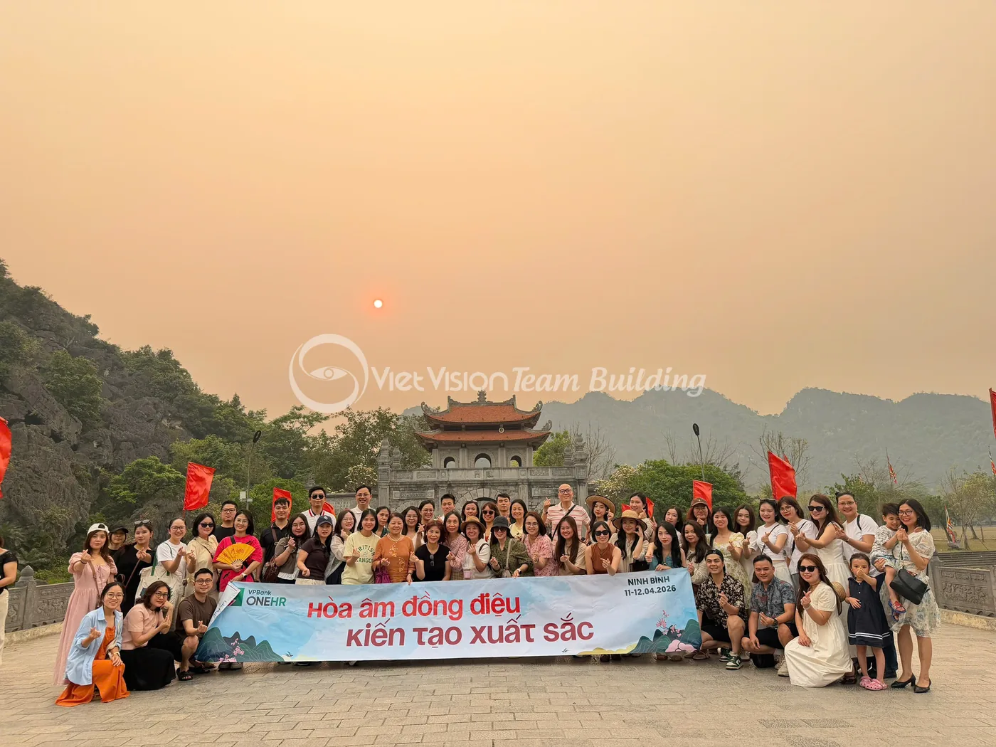 Tập thể doanh nghiệp chụp ảnh cùng banner thông điệp trong chương trình team building