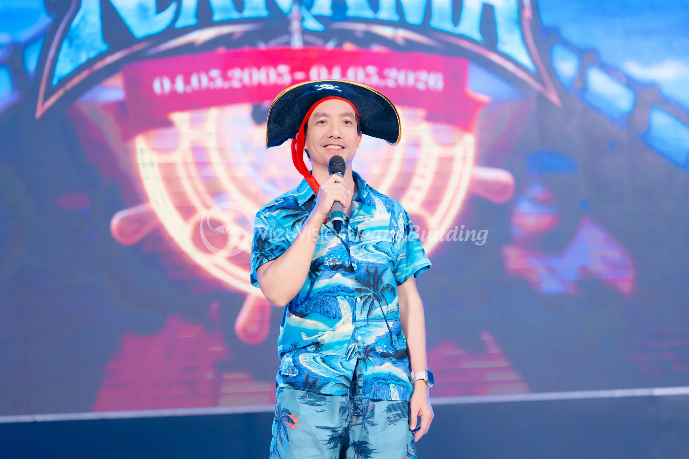 MC đứng trên sân khấu giới thiệu tên chủ đề team building