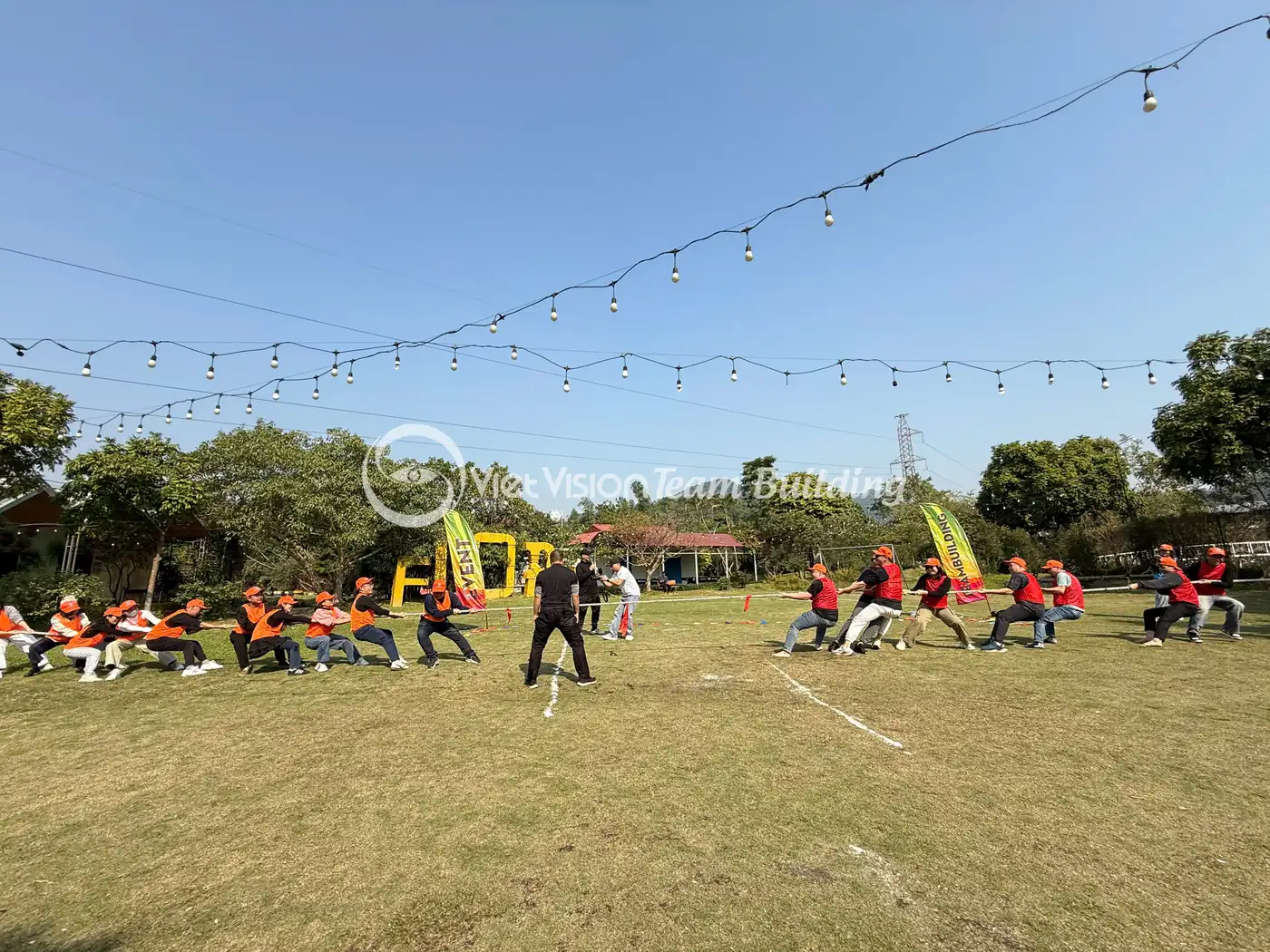 Đội chơi xếp line trên sân cỏ rộng trong chương trình team building