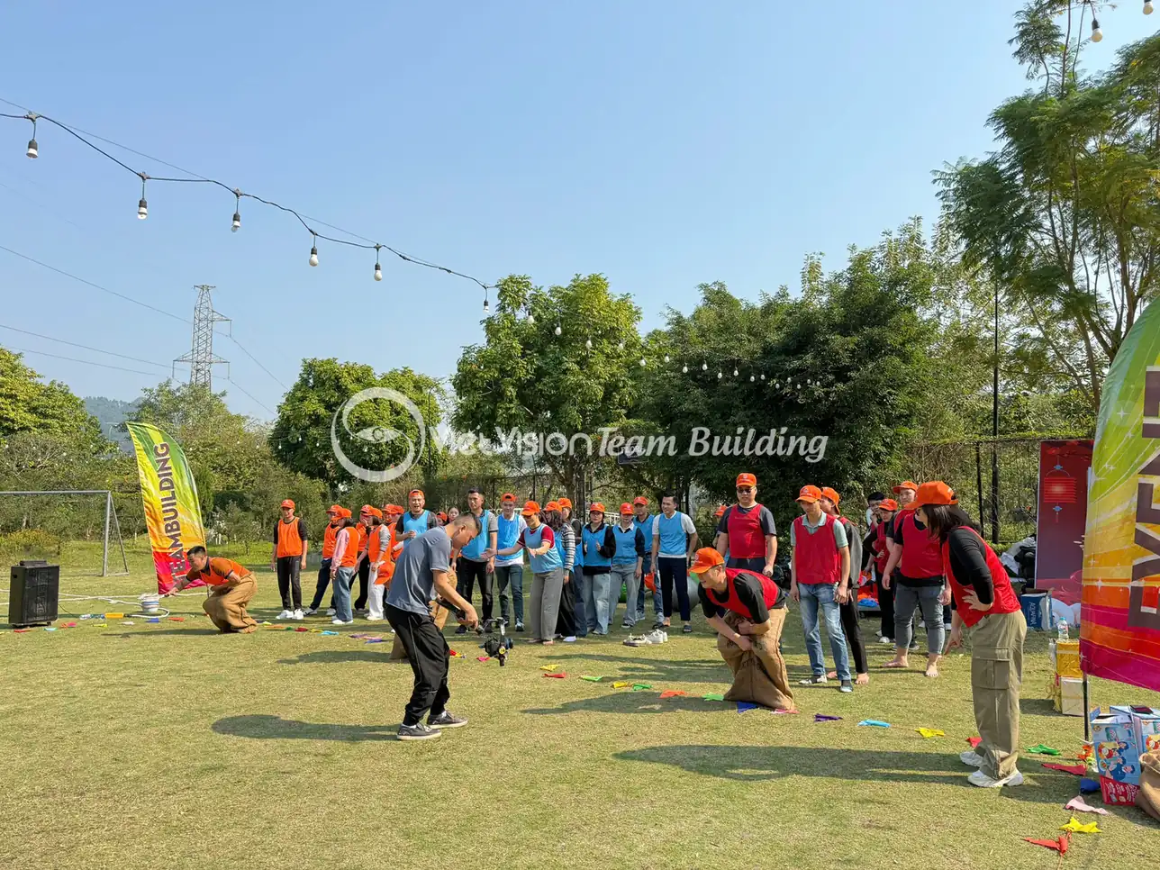 Đội chơi tập trung trước backdrop tại khu vực team building ngoài trời