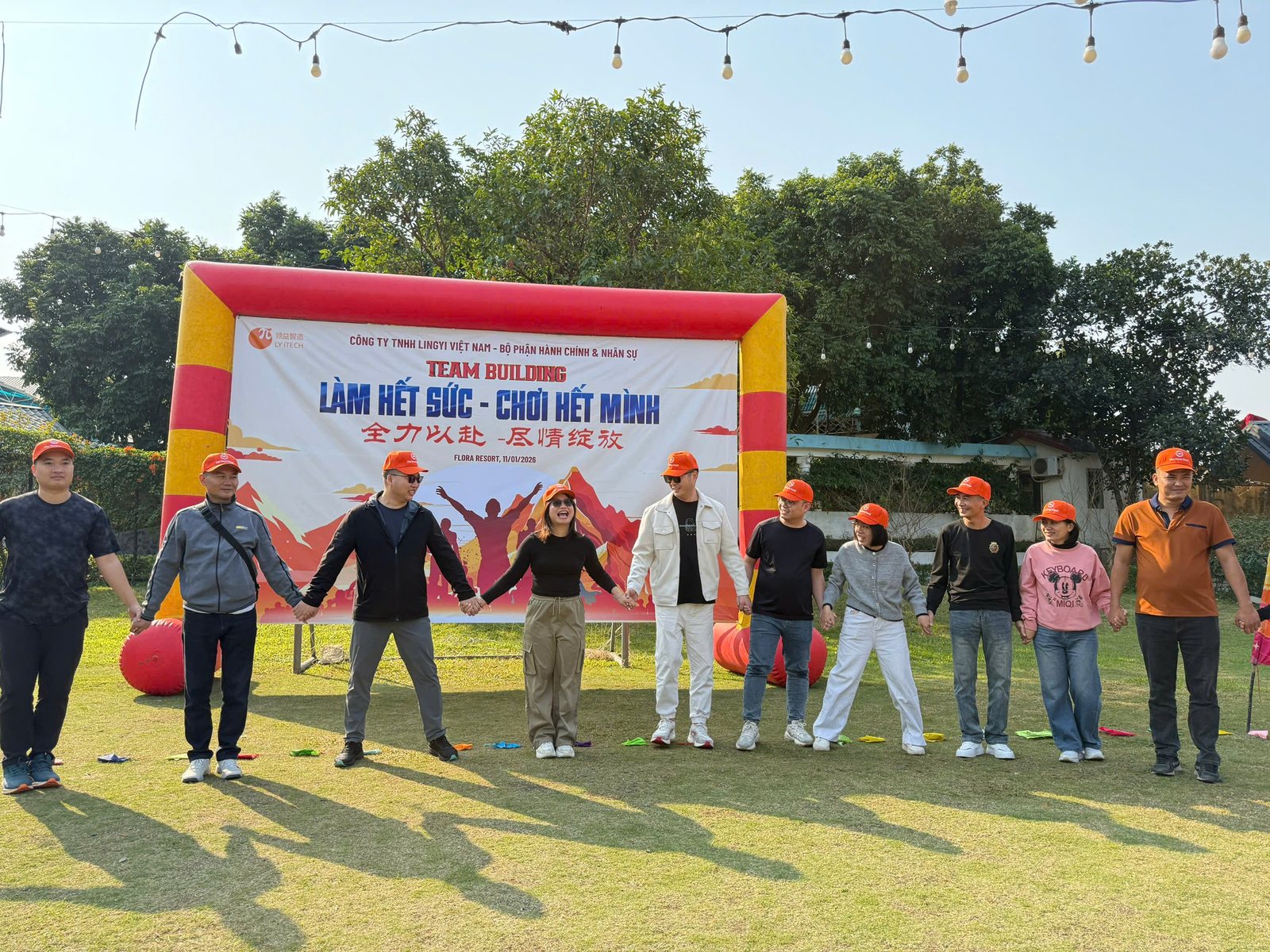 Nhóm nhân sự tham gia trò chơi team building không cần đạo cụ trên sân cỏ