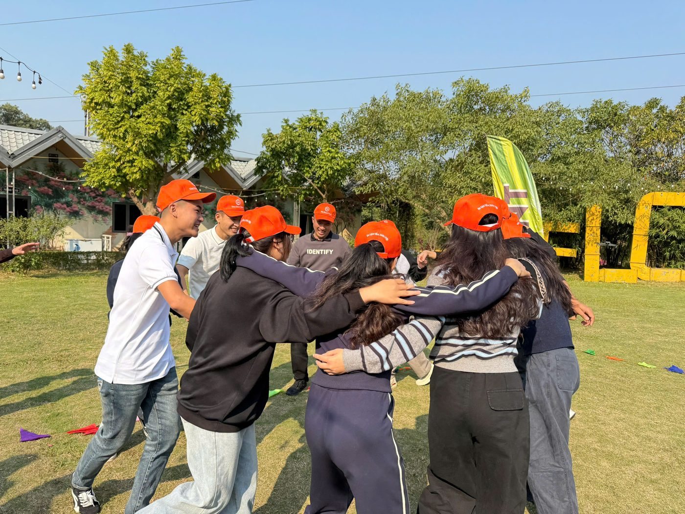 Nhóm thành viên khoác vai tạo vòng kết nối trong hoạt động team building